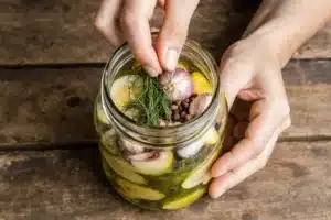 Quick Pickle Recipe: Ready in 30 Minutes with Crunchy Flavor 6 Spices and herbs being added to jar for quick pickle recipe