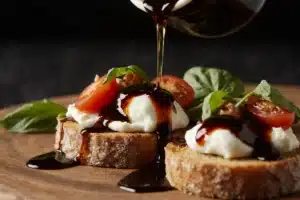 Olive oil and balsamic glaze drizzled over burrata bruschetta appetizer