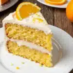 Orange Dreamsicle Cake slice with orange cream cheese frosting and orange layers