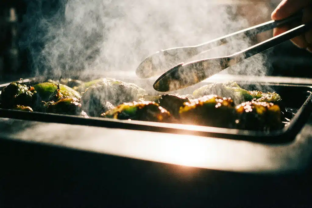 Roasting poblano peppers over flame for tamales de rajas con queso filling