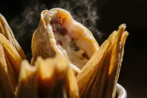Steaming tamales de rajas con queso in traditional steamer basket