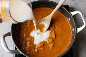 Authentic Makhani Sauce Recipe | Easy Butter Chicken Sauce 8 Pouring cream and honey into makhani sauce for balanced flavor