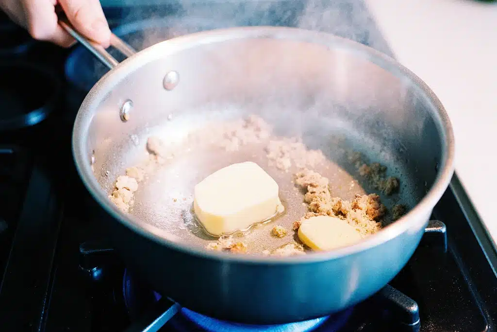 How to Make the Perfect Asiago Cream Sauce (Best Recipe + Tips) 11 Butter melting with minced garlic sautéing in a saucepan for Asiago cream sauce