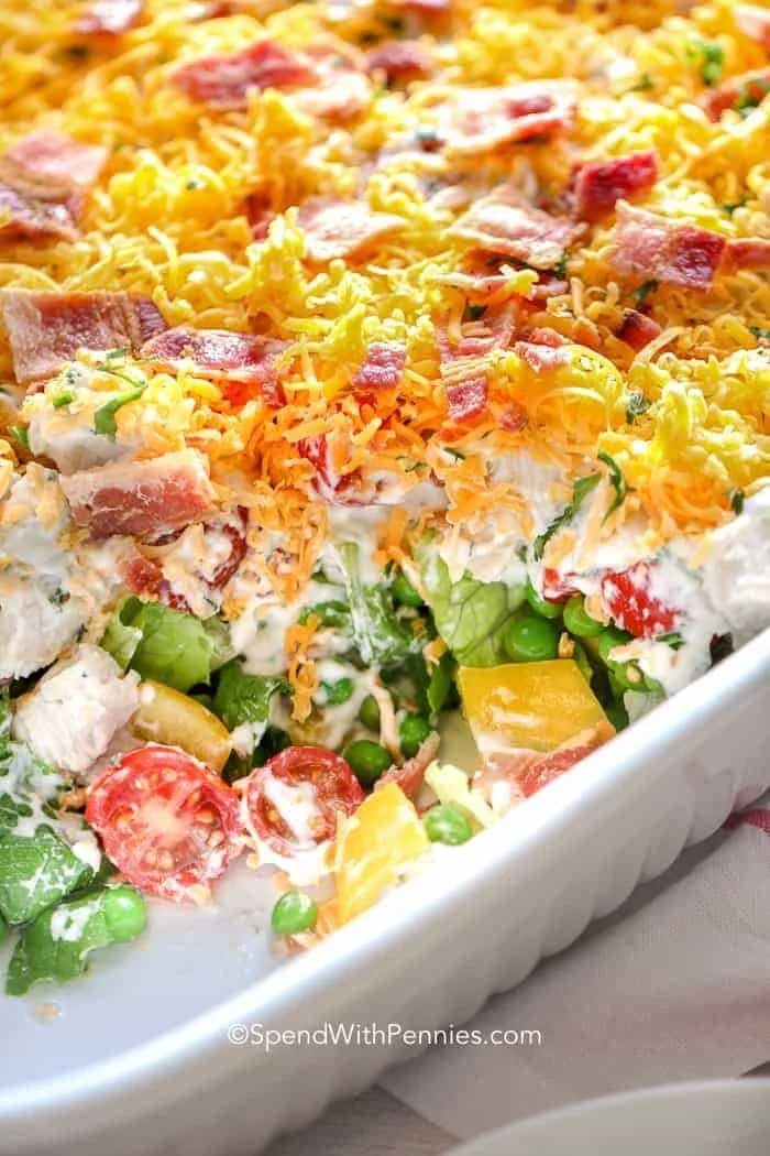 7 Layer Salad 1 A colorful 7 Layer Salad with fresh vegetables and creamy dressing in a glass dish