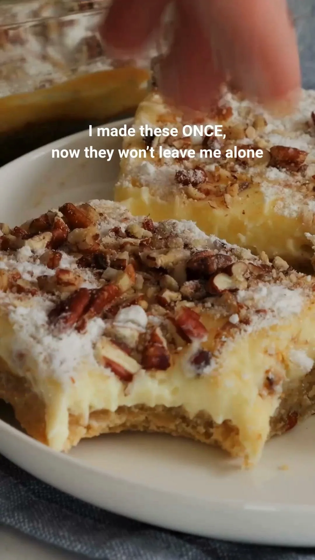 Cheesecake Bars with Pecans 1 Delicious cheesecake bars topped with pecans on a white plate